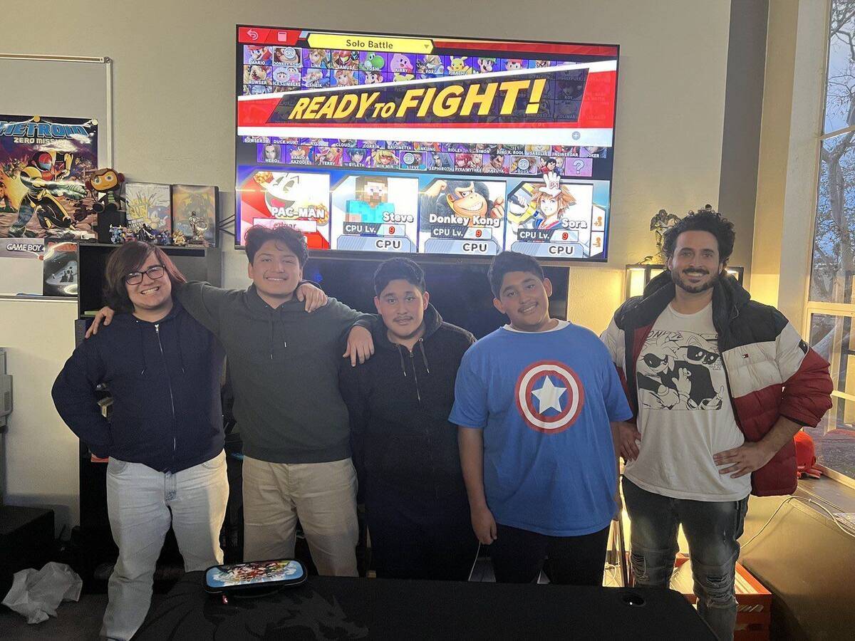 Four Team Kairon Smash players and Mr. Darien in front of the Ready to Fight screen